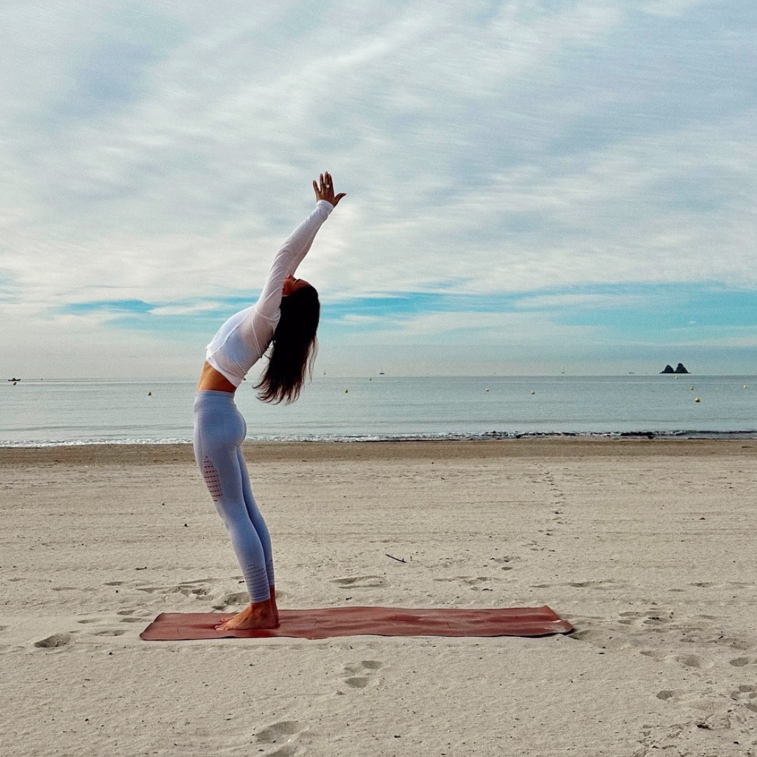 jeune femme qui fait du yoga sur la plage Image